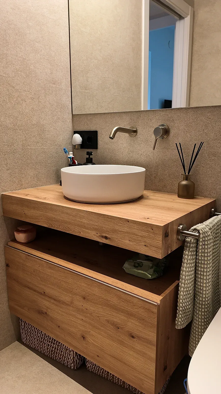 Lavabo redondo sobre encimera de madera maciza con grifería empotrada, baño de Castelldefels