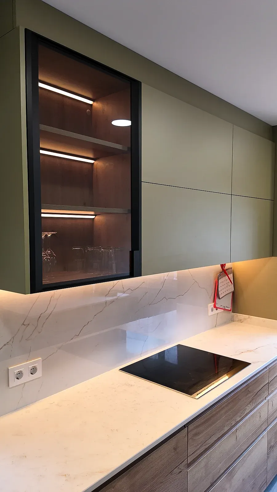 Vitrina con baldas iluminadas por LED y copas, sobre la encimera Neolith en Terrassa