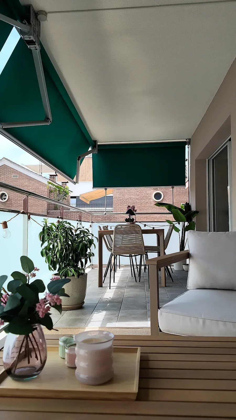 Terraza con toldo verde, zona de comedor y plantas, reforma integral de Castelldefels